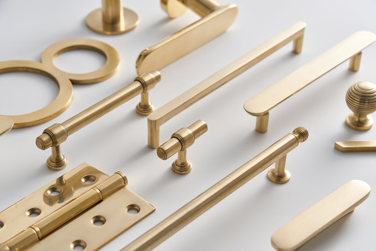 Close view of polished unlacquered brass pulls, T-bars and a house number