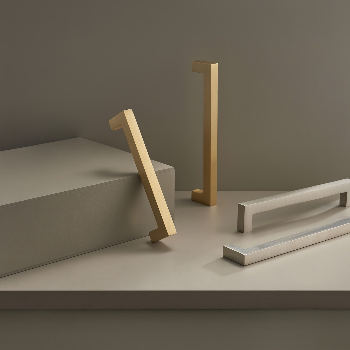 FYRA solid brass bar handles in satin brass and satin nickel, styled on a plinth