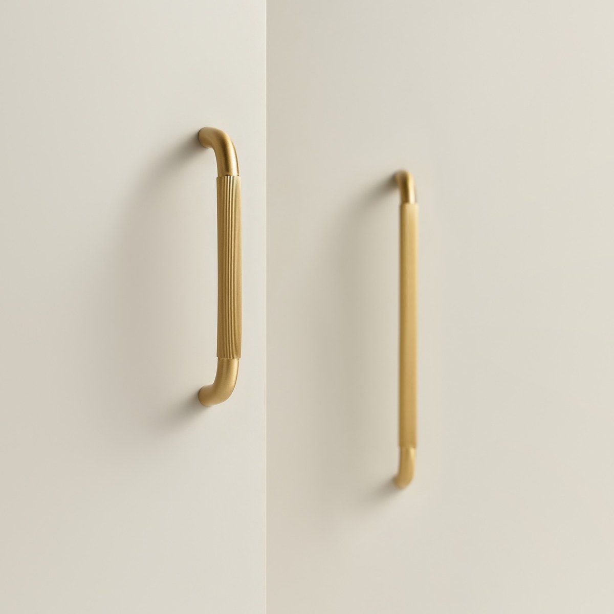 RIGA bar handles in satin brass fitted to pale cabinet doors