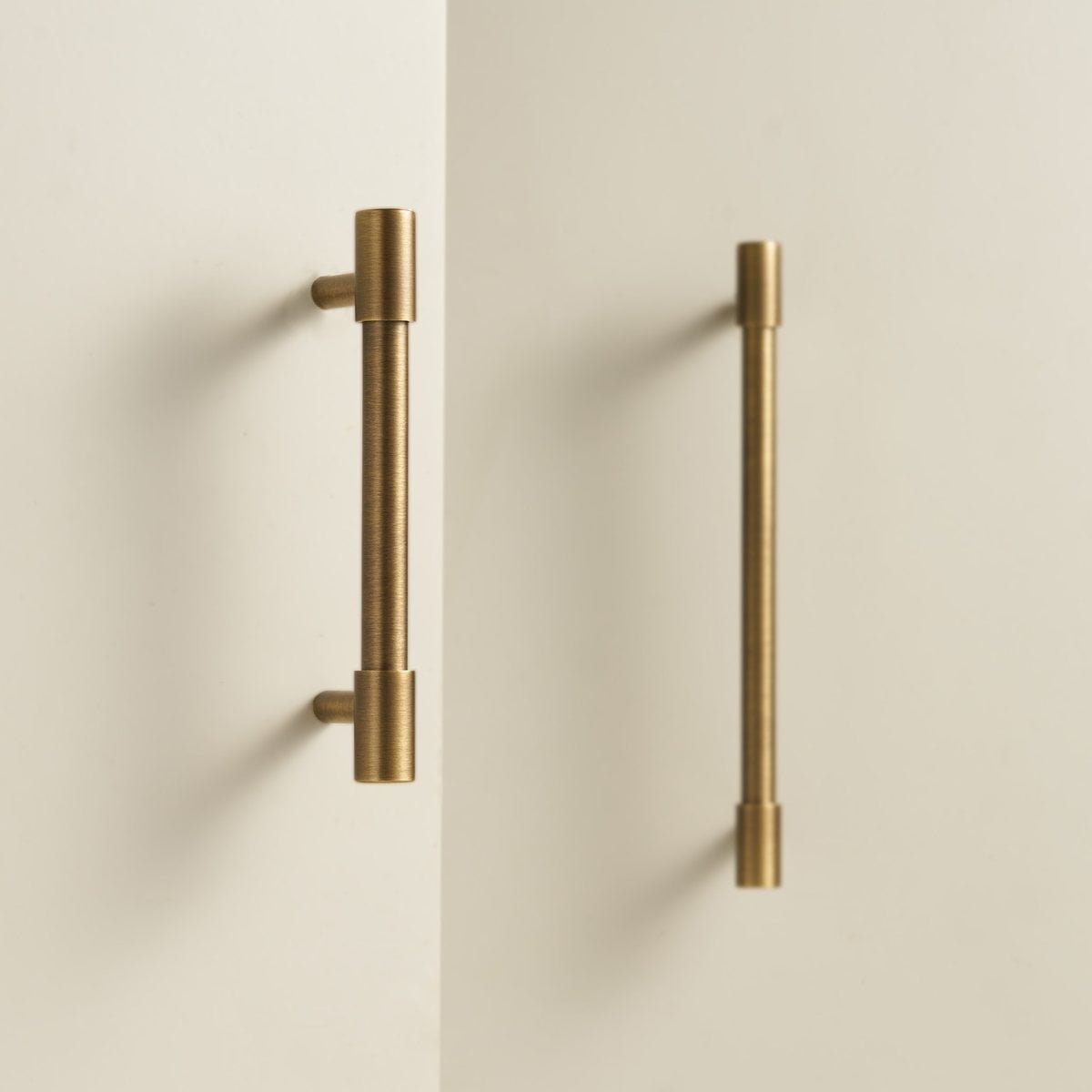 RAND solid brass bar handles in satin brass fitted to a pair of pale cabinet doors